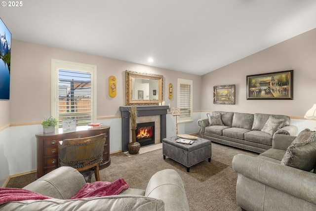 living room with a tile fireplace, lofted ceiling, and light carpet