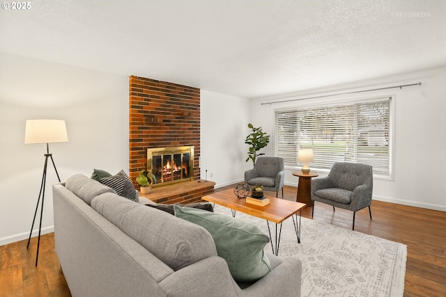 living room with a fireplace, baseboards, and wood finished floors