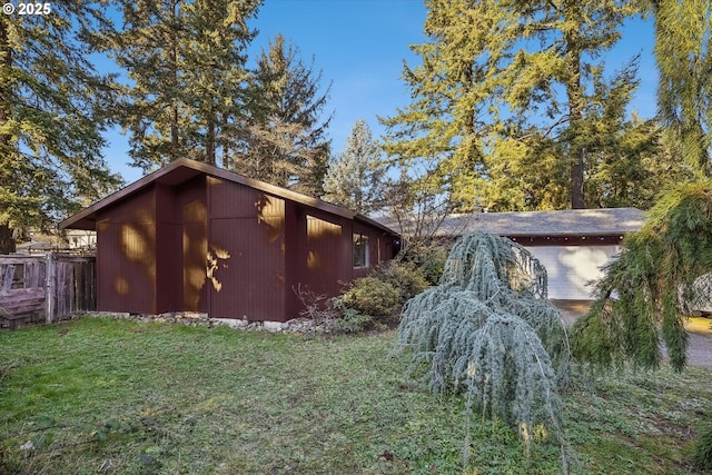 view of side of home with a yard and fence