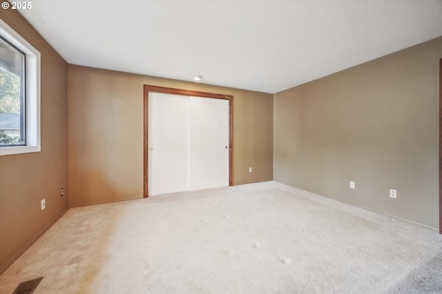 unfurnished room with visible vents and light carpet