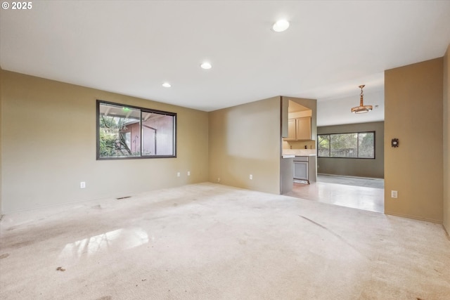 unfurnished living room featuring recessed lighting and light carpet