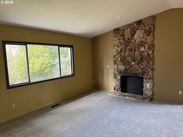 unfurnished living room featuring visible vents, carpet, a fireplace, and vaulted ceiling