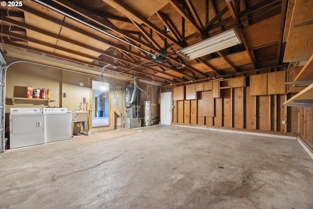 garage with water heater, washer and dryer, and a sink