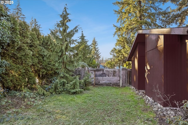 view of yard featuring an outbuilding and fence