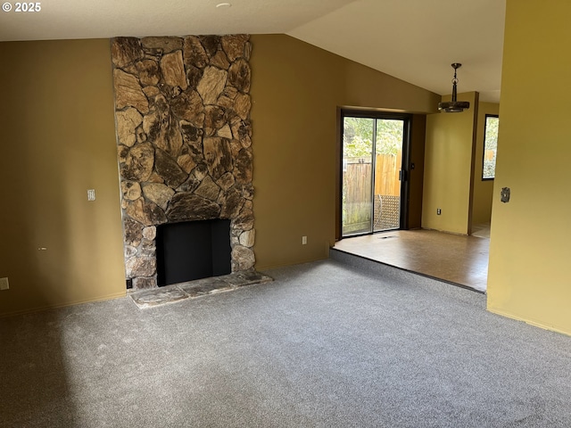 unfurnished living room featuring a fireplace, lofted ceiling, and carpet