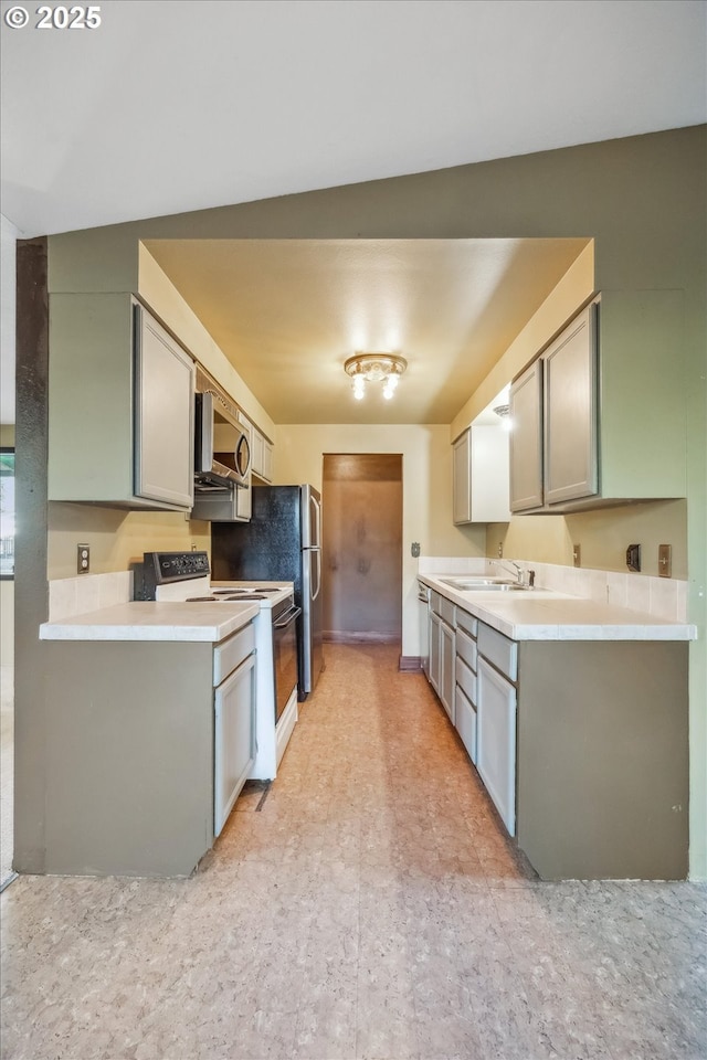 kitchen featuring electric range, gray cabinets, a sink, light countertops, and stainless steel microwave