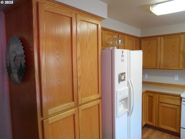 4471 Spring Meadow Ave, Eugene, OR 97404 - kitchen featuring white fridge with ice dispenser, light countertops, light wood-style floors, and brown cabinets