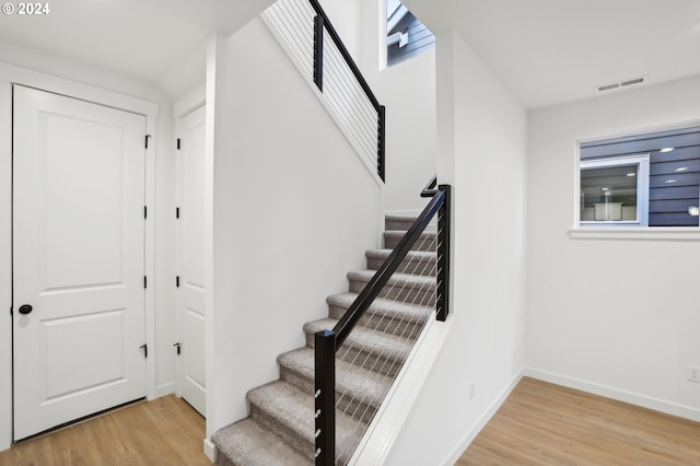 stairs featuring visible vents, baseboards, and wood finished floors