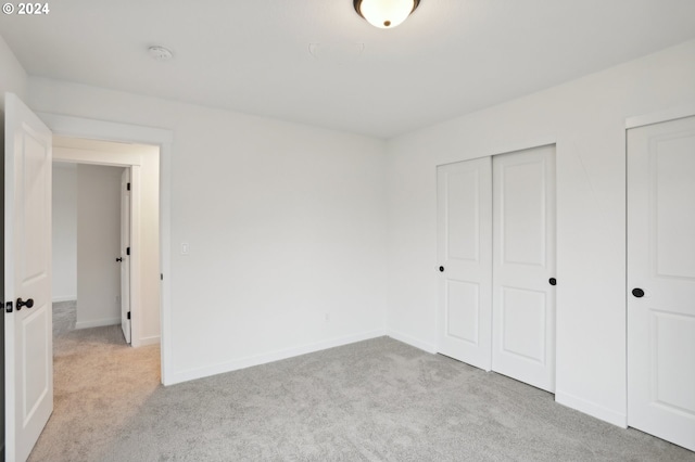 unfurnished bedroom featuring light colored carpet and baseboards