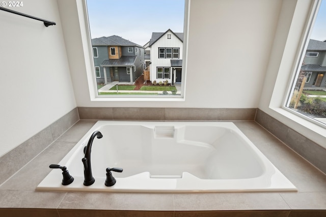 bathroom with a relaxing tiled tub and a residential view