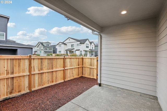 view of patio with fence and a residential view