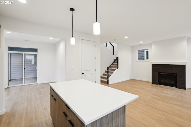 kitchen with a kitchen island, open floor plan, light countertops, hanging light fixtures, and modern cabinets