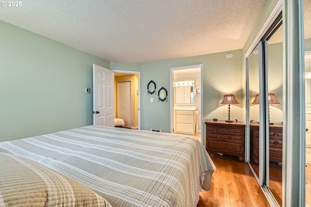 2433 NE Saratoga St, Portland, OR 97211 - bedroom with a textured ceiling, a closet, light wood-style flooring, and connected bathroom