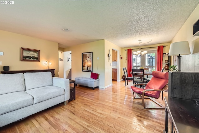 2433 NE Saratoga St, Portland, OR 97211 - living area featuring a textured ceiling, baseboards, a chandelier, and light wood finished floors