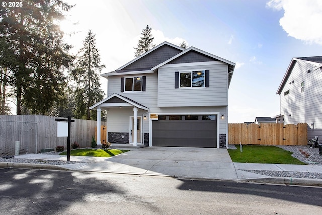 view of front of property featuring concrete driveway, fence, and stone siding