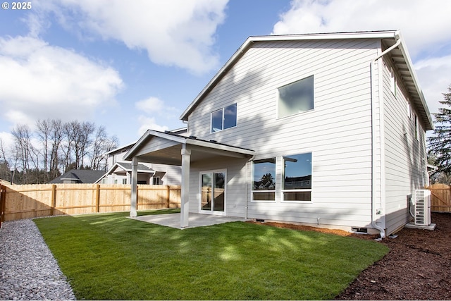 rear view of property with a lawn, a fenced backyard, and a patio area