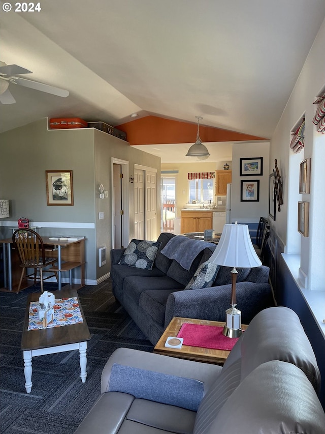 living room featuring ceiling fan, carpet flooring, and vaulted ceiling