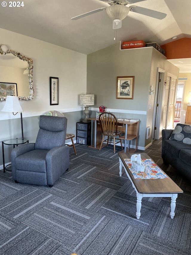 carpeted living room with ceiling fan and vaulted ceiling