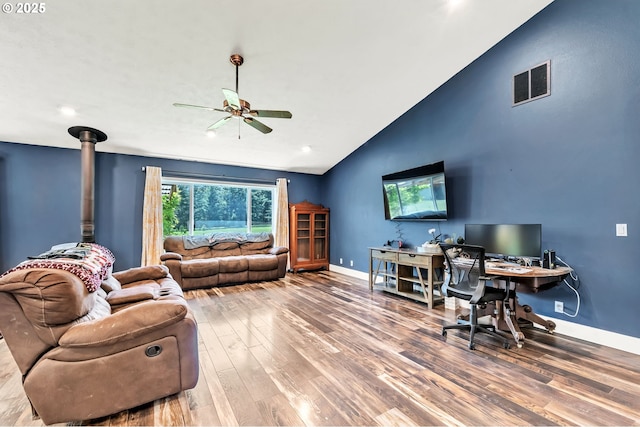 39225 SW Oak Ln, Willamina, OR 97396 - living room with lofted ceiling, a ceiling fan, wood finished floors, a wood stove, and baseboards