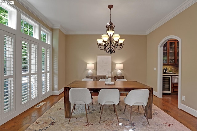 dining room featuring wine cooler, ornamental molding, hardwood / wood-style floors, and visible vents
