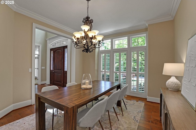 dining area with an inviting chandelier, baseboards, and crown molding