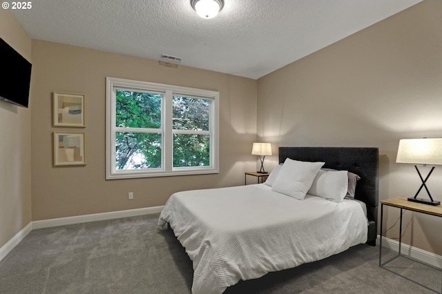 bedroom featuring carpet flooring, a textured ceiling, visible vents, and baseboards