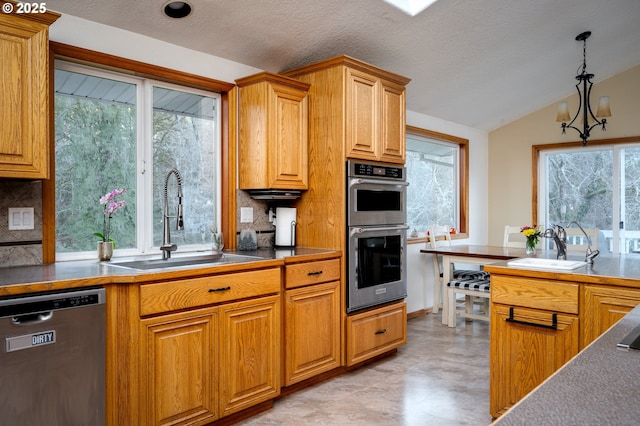 kitchen featuring appliances with stainless steel finishes, sink, decorative light fixtures, an inviting chandelier, and lofted ceiling