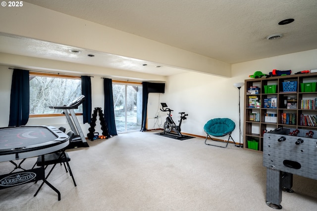 exercise room with carpet floors and a textured ceiling