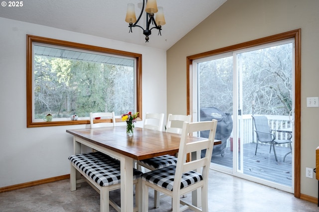 dining area featuring a chandelier, a wealth of natural light, and lofted ceiling