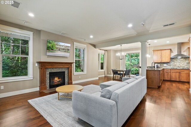 4520 Trillium, Woods, Lake Oswego, OR 97035 - living room featuring baseboards, dark wood-type flooring, a chandelier, a fireplace with flush hearth, and recessed lighting