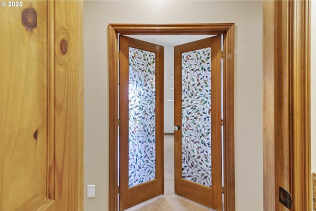 doorway with french doors and light tile patterned floors