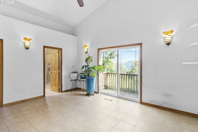 tiled empty room with ceiling fan and vaulted ceiling