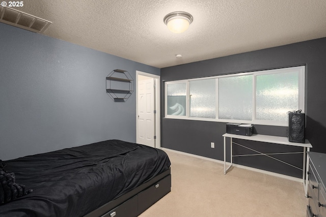 bedroom featuring light carpet, visible vents, a textured ceiling, and baseboards