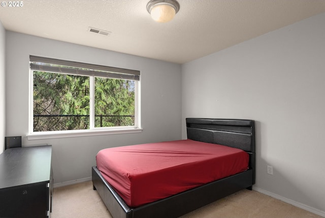 bedroom with visible vents, baseboards, carpet, and a textured ceiling