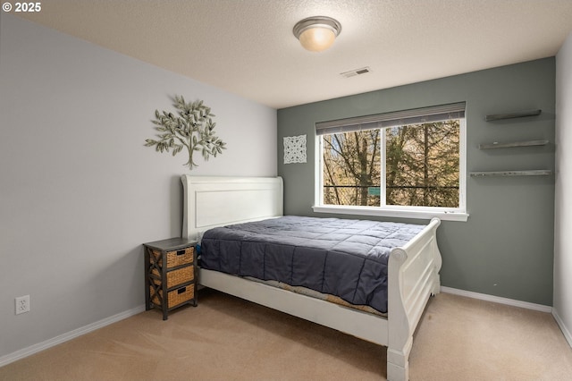 bedroom featuring a textured ceiling, baseboards, visible vents, and light carpet