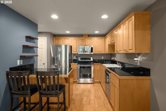 kitchen featuring a sink, light wood-style flooring, a peninsula, stainless steel appliances, and open shelves