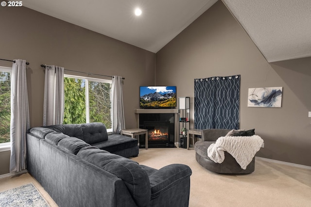 living area with baseboards, light carpet, high vaulted ceiling, and a fireplace with flush hearth