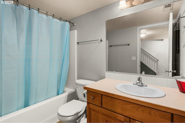 bathroom with visible vents, shower / tub combo with curtain, vanity, and toilet