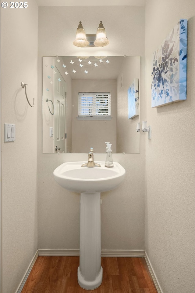 bathroom with baseboards and wood finished floors