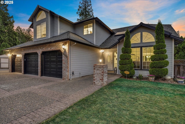 view of front of house with a garage and a yard