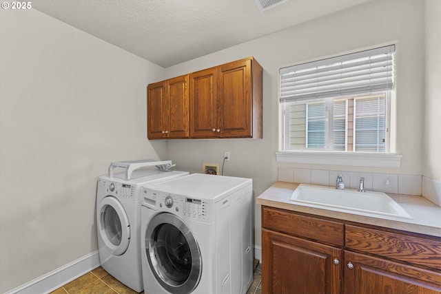 11168 SW Brown St, Tualatin, OR 97062 - laundry area featuring cabinet space, separate washer and dryer, baseboards, and tile patterned flooring