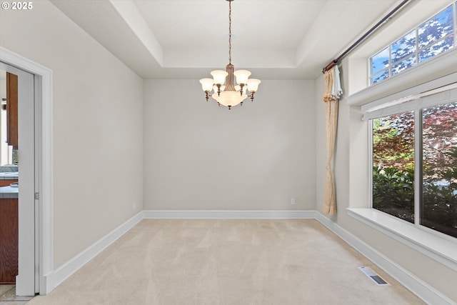 11168 SW Brown St, Tualatin, OR 97062 - spare room with a chandelier, a tray ceiling, light colored carpet, and baseboards
