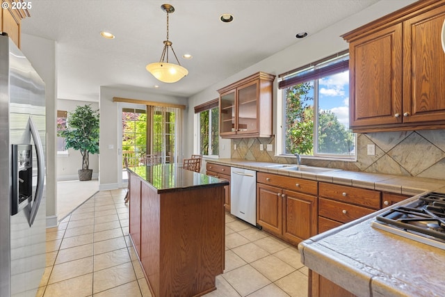 11168 SW Brown St, Tualatin, OR 97062 - kitchen with stainless steel appliances, a sink, decorative backsplash, recessed lighting, and a kitchen island