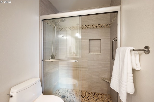 bathroom featuring an enclosed shower and toilet