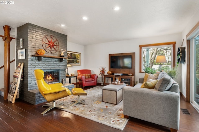 living room with dark hardwood / wood-style flooring, a fireplace, and a textured ceiling