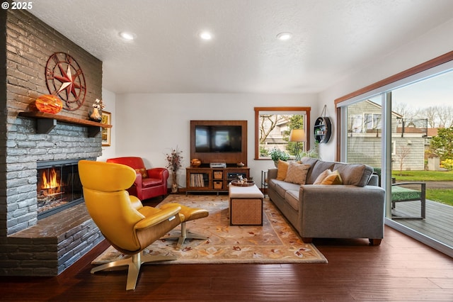 living room featuring a fireplace, hardwood / wood-style floors, and a textured ceiling