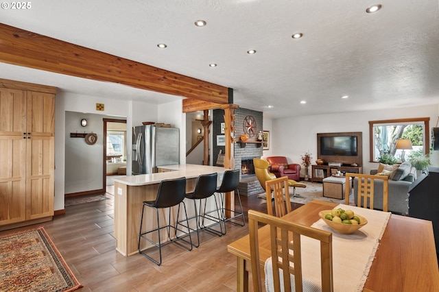 dining room with a large fireplace and a textured ceiling