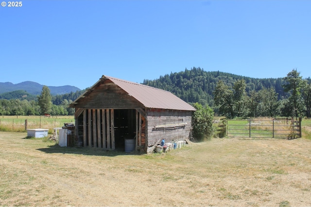 view of horse barn featuring a rural view and a mountain view