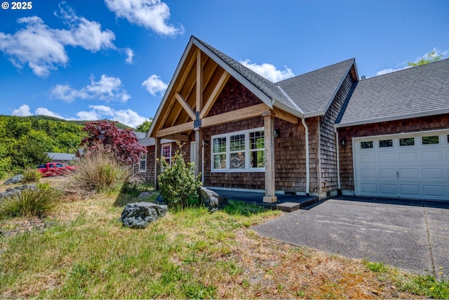 1430 N Cedar Creek Cir, Rockaway Beach, OR 97136 - view of front of house with a shingled roof, a garage, and asphalt driveway
