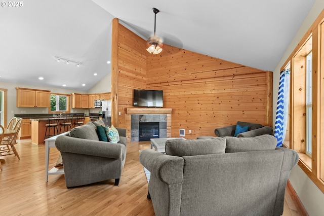 1430 N Cedar Creek Cir, Rockaway Beach, OR 97136 - living room with wooden walls, light wood finished floors, recessed lighting, a tile fireplace, and high vaulted ceiling